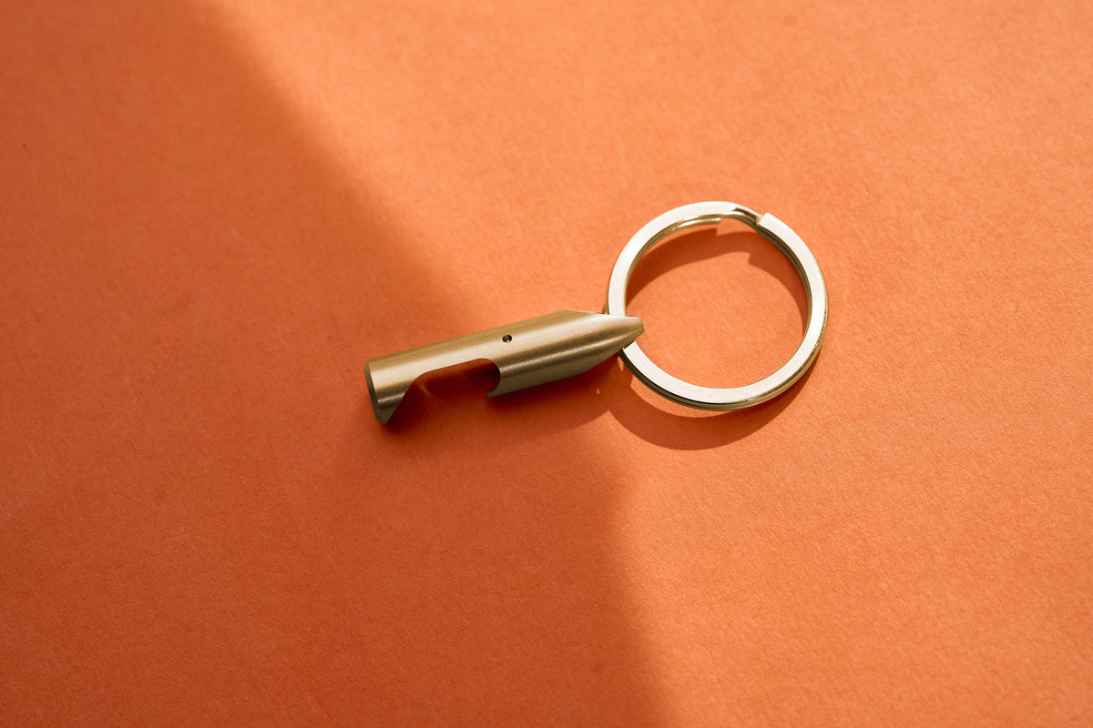 Bottle Opener - Brass on its key ring, flat lay
