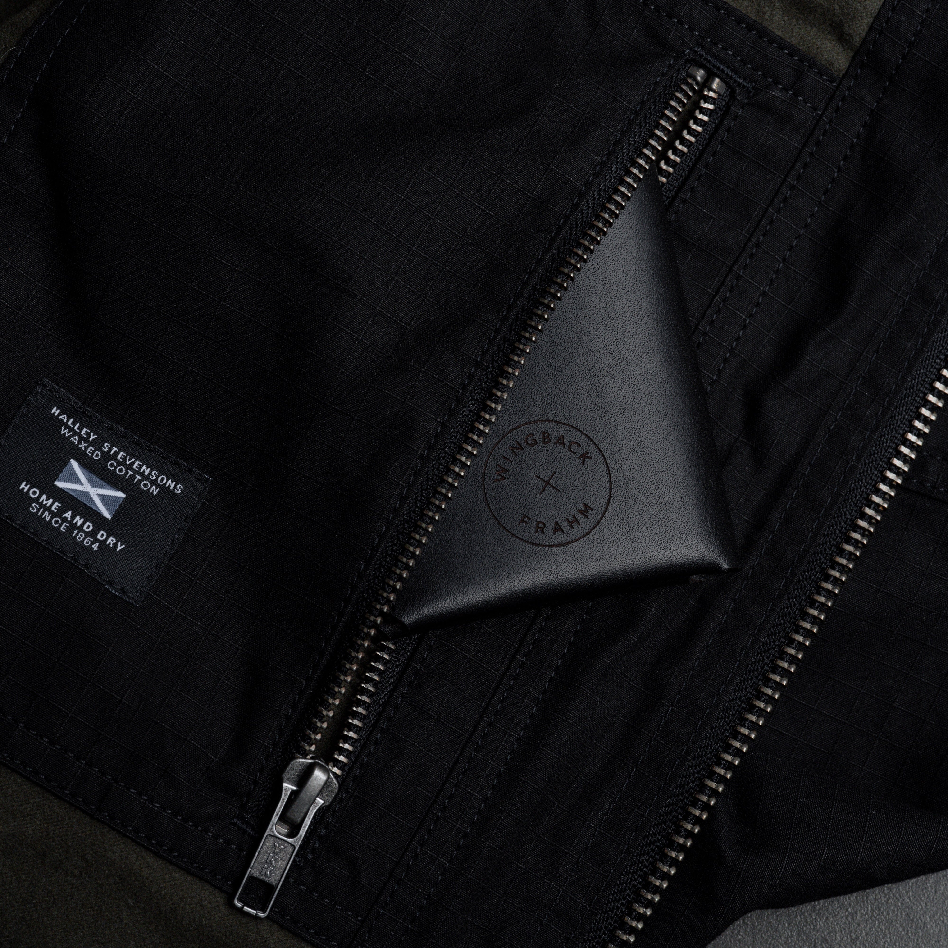 Close-up of a black jacket with a zipper and brand logo.