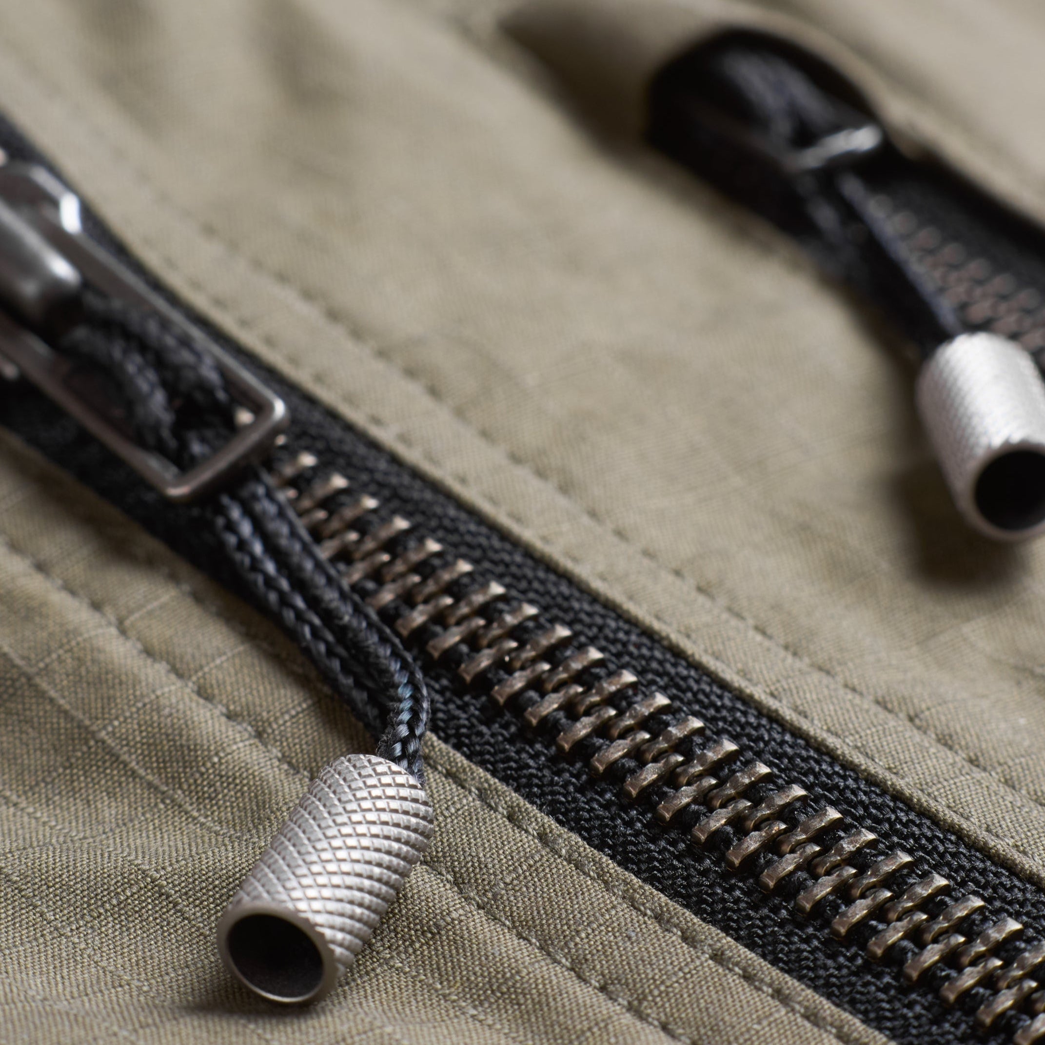 Close-up of a zipper on a green cotton jacket