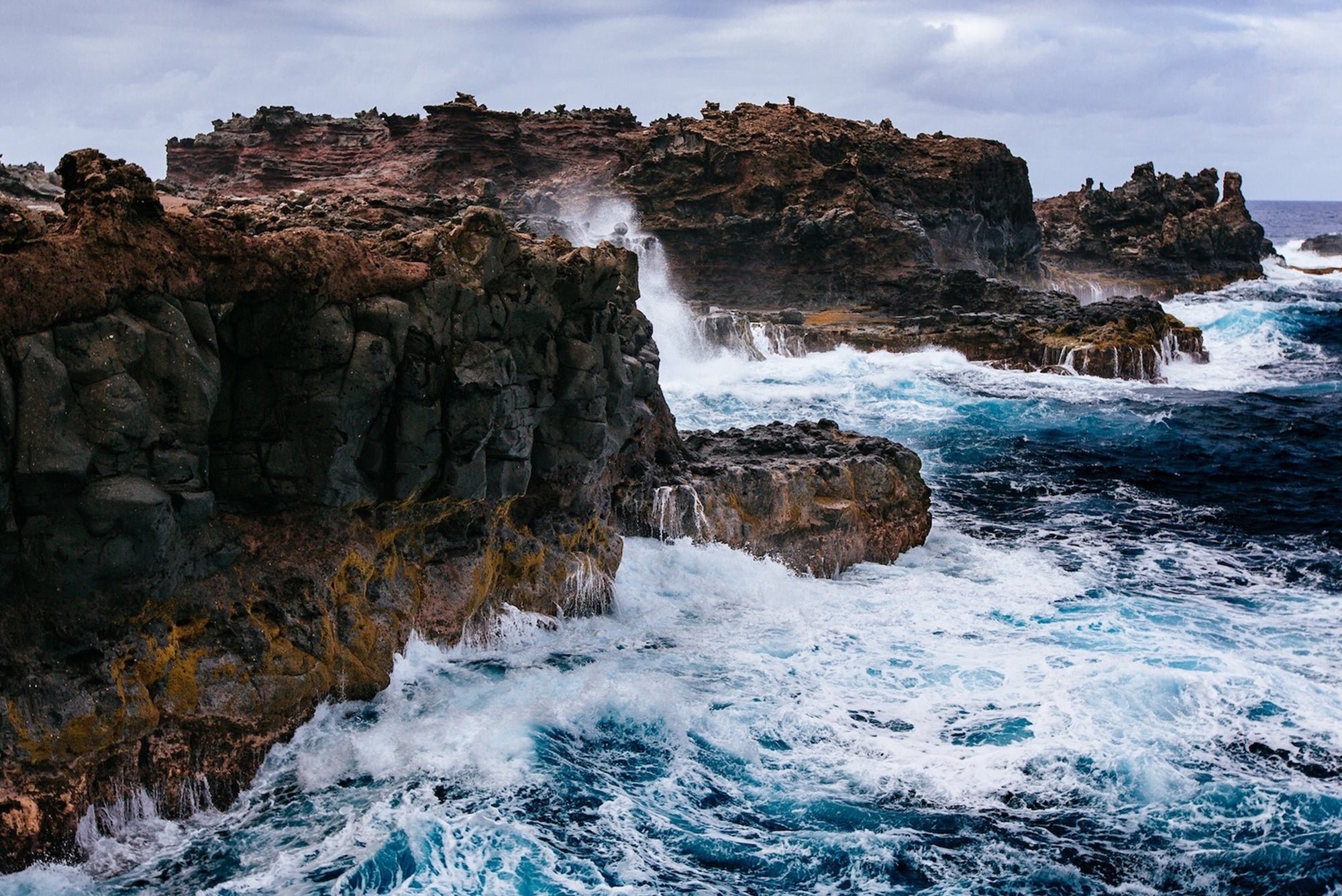 Waves crashing against cliffs via Unsplash