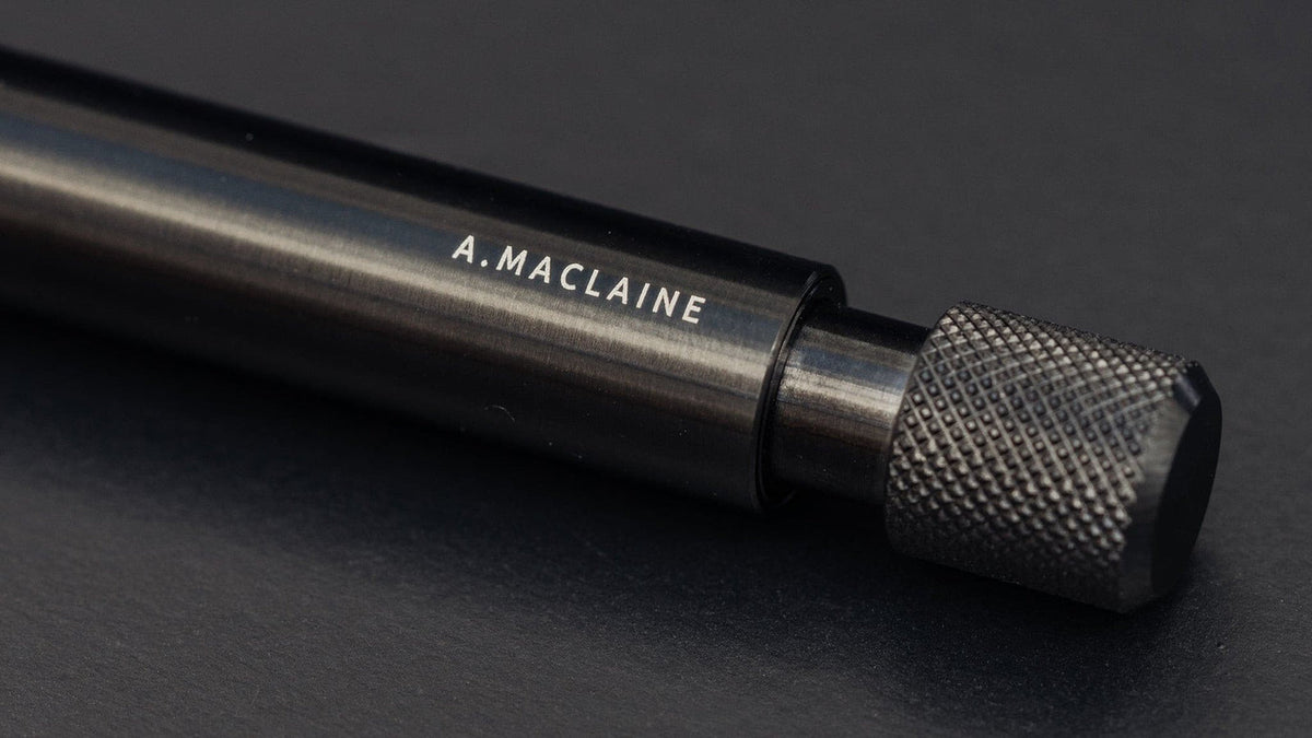 Black steel mechanical pen engraved with a name along the barrel 
