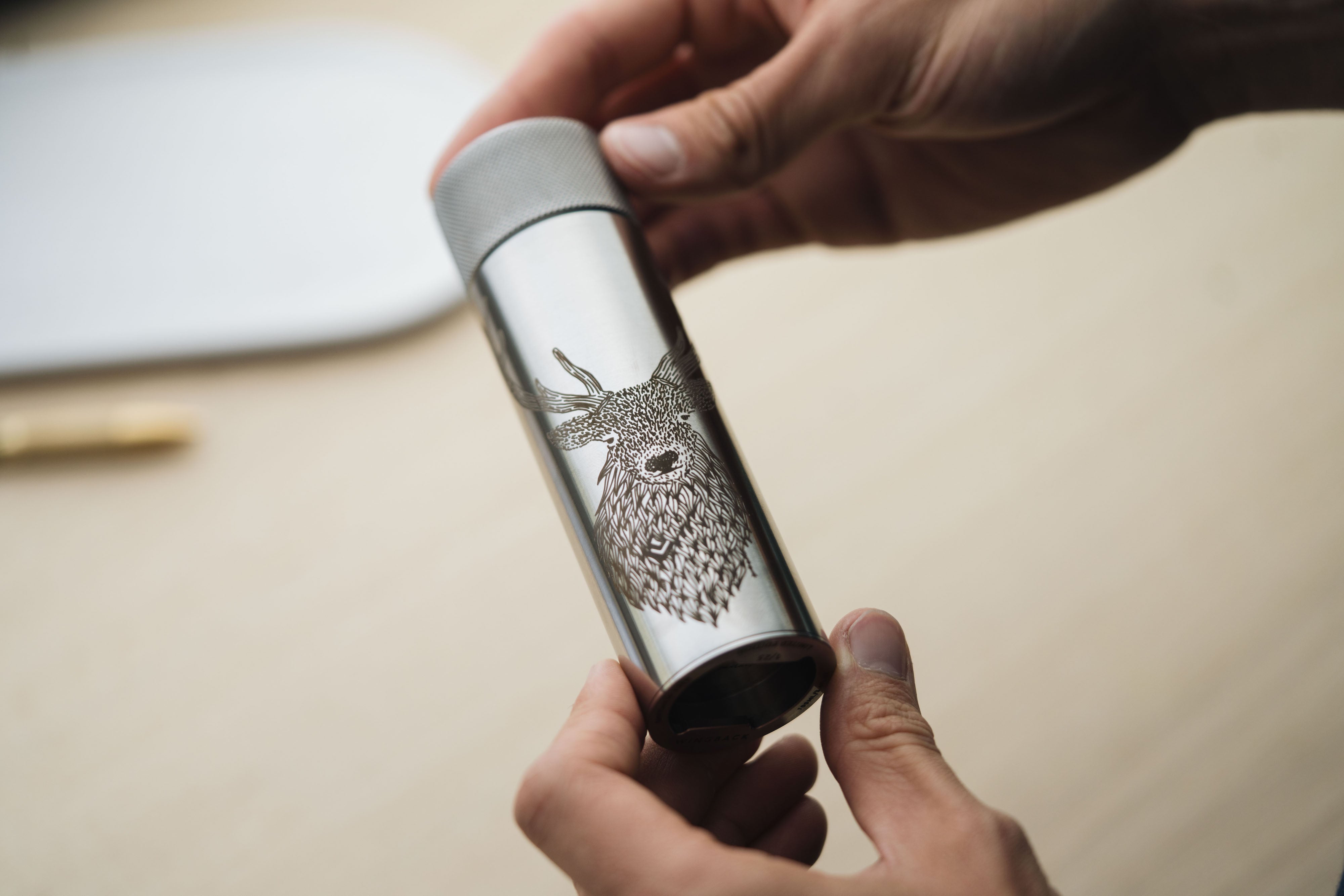 Stainless steel hip flask by Wingback engraved with an illustration of a red stag by artist Os Illustration