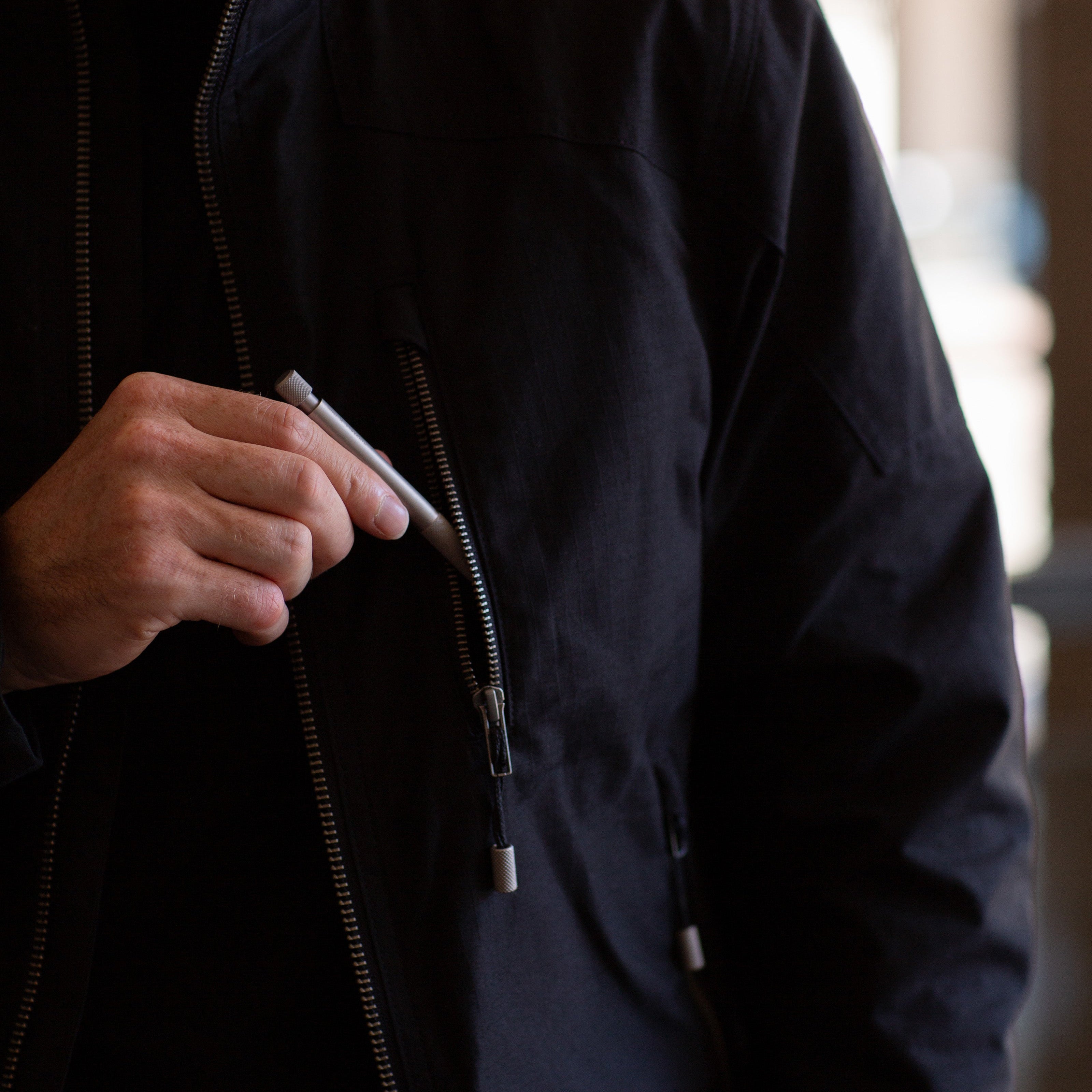 Person wearing a black jacket with a blurred background