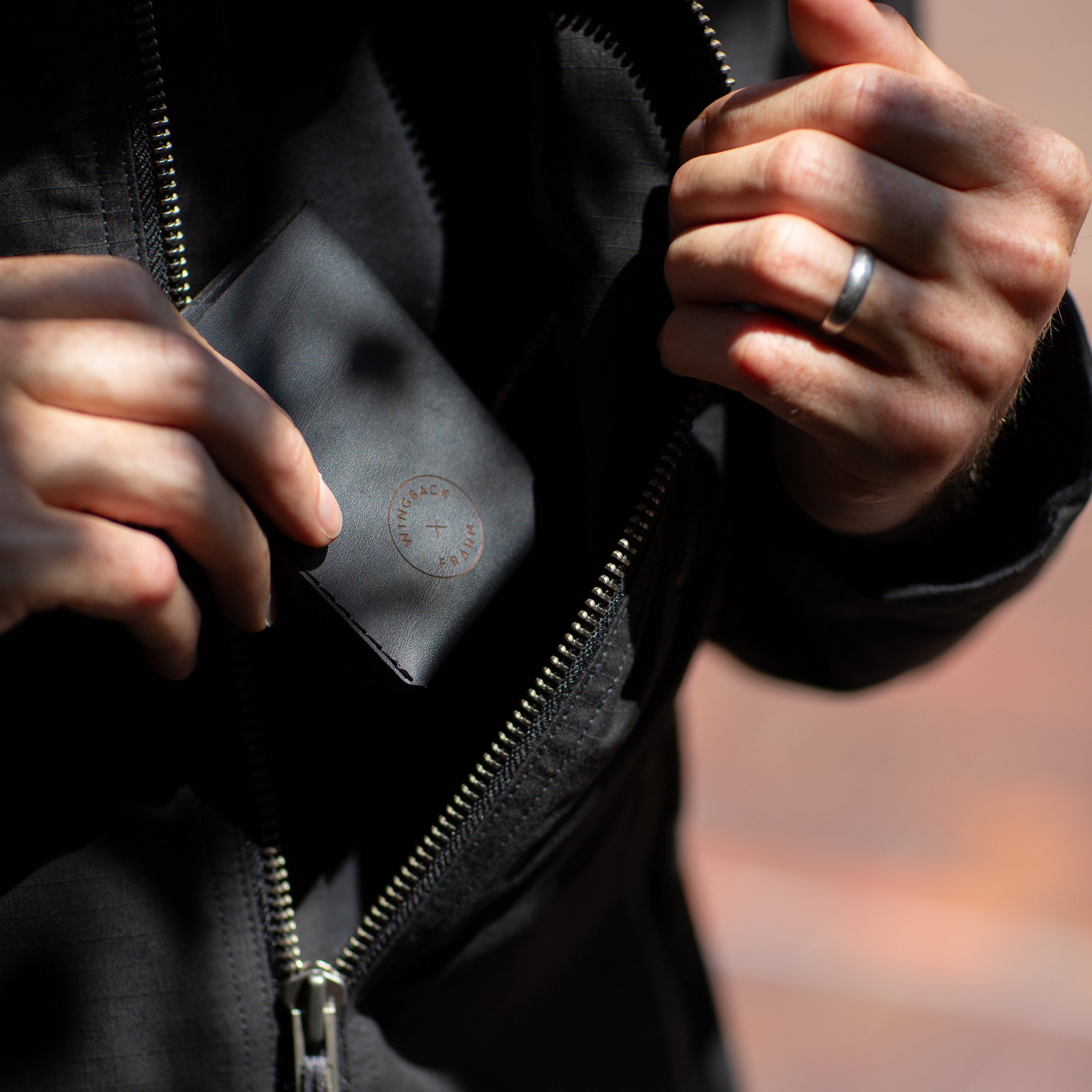 Person holding a black wallet with a blurred background